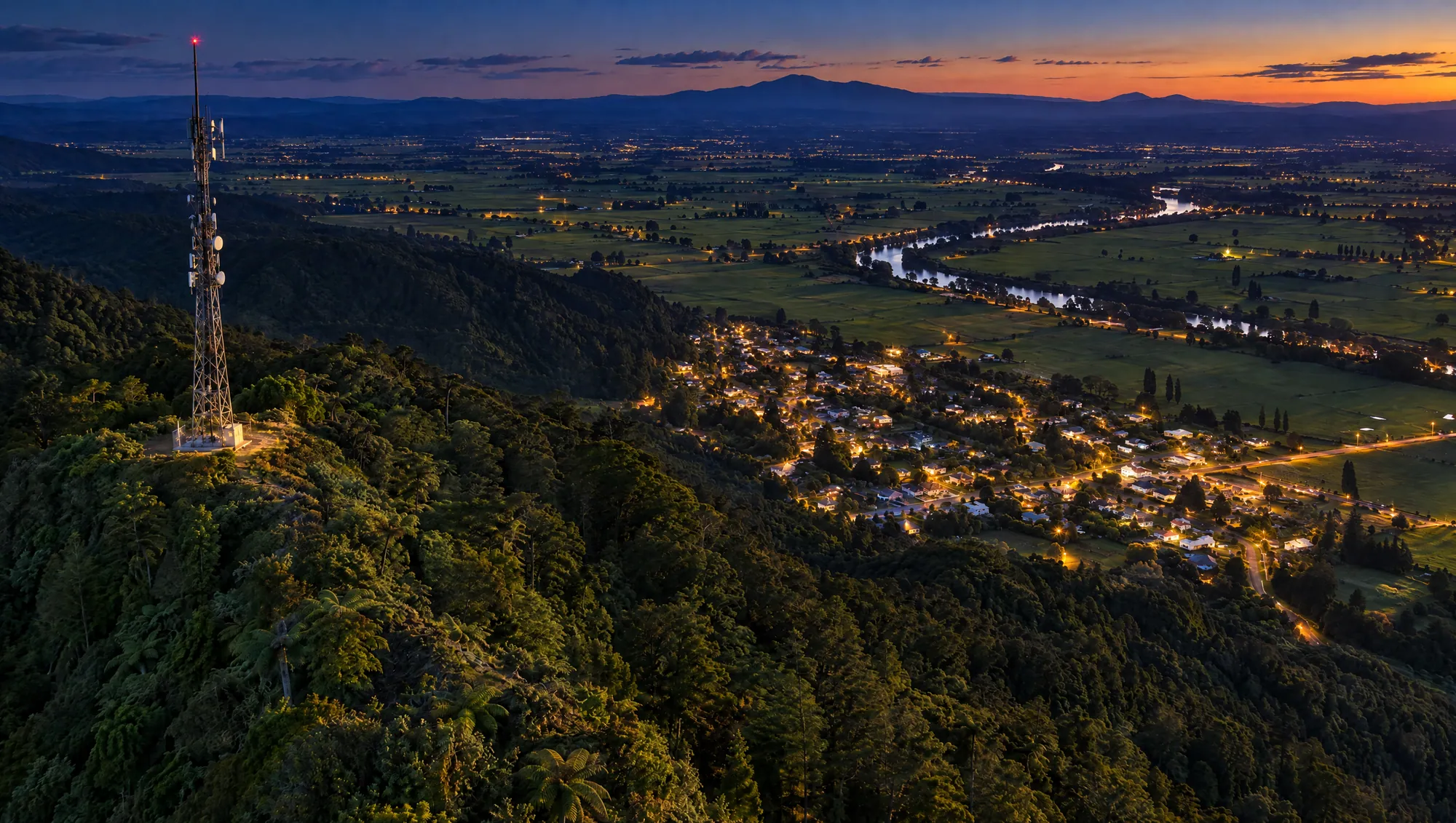 Illustrative view: a Waikato town at dusk below the mountain, its lights coming on